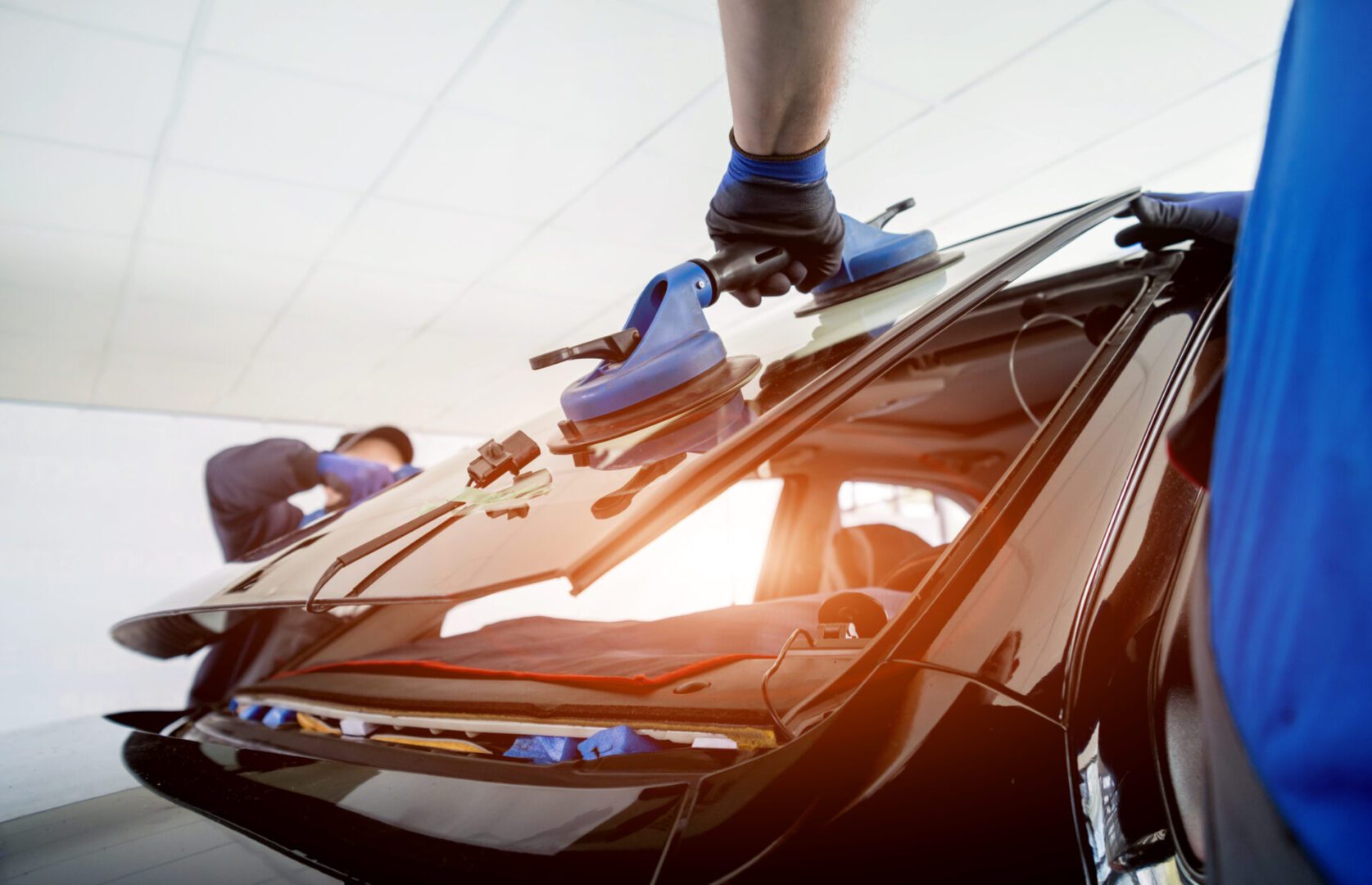 Glassmobile technician setting a new windshield with suction handles